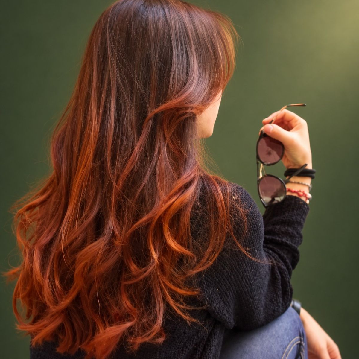 Cabelo longo em ondas castanho acobreado, visto de costas