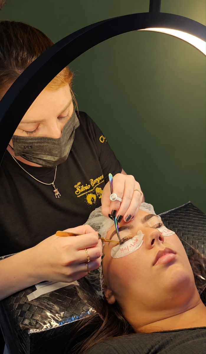 Profissional do studio aplicando alongamento de cílios