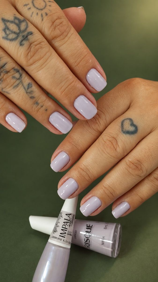 Unhas em lilás claro e dois esmaltes